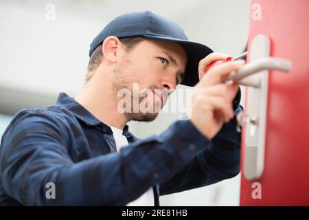 bricoleur réparateur de porte avec tournevis Banque D'Images