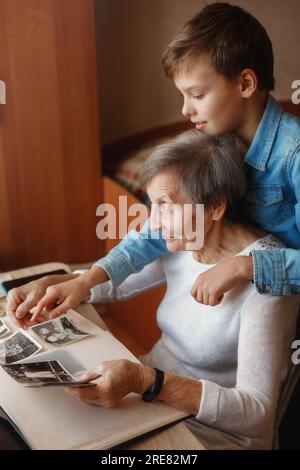 Grand-mère avec arrière-petit-fils regardant de vieilles photos Banque D'Images