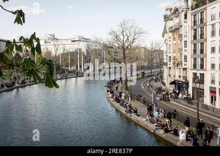 Une vue surélevée des gens sur la rive du canal dans le quartier prometteur du Canal Saint Martin à Paris, par une belle journée de printemps. Banque D'Images