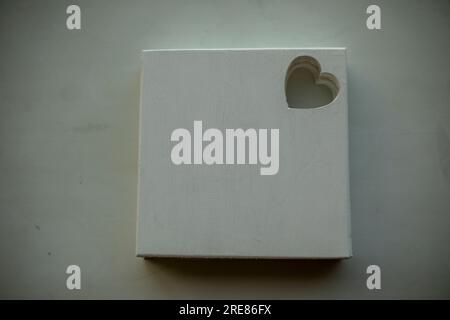 Tableau blanc pour la créativité. Arrière-plan de l'image. Planche de bois peinte en blanc. La forme du coeur est sculptée dans la planche. Banque D'Images