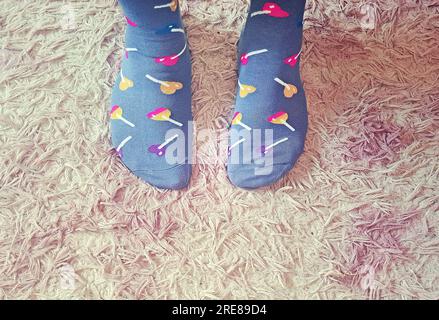 Gros plan des pieds d'une personne portant des chaussettes de fantaisie avec sucettes Banque D'Images