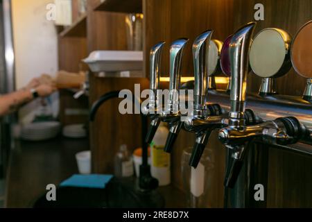 Les robinets chromés pour la bière pression dans un bar moderne. Détail de la machine à bière, distributeur de bière, gros plan, mise au point sélective, style rétro Banque D'Images