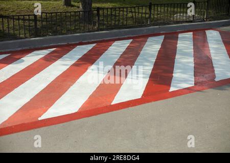 Plate-forme pour équipement d'incendie. Parking pour pompiers. L'asphalte est peint en bandes. Bandes rouges et blanches sur la route. Banque D'Images