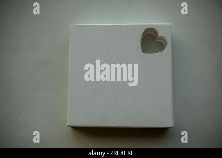 Tableau blanc pour la créativité. Arrière-plan de l'image. Planche de bois peinte en blanc. La forme du coeur est sculptée dans la planche. Banque D'Images