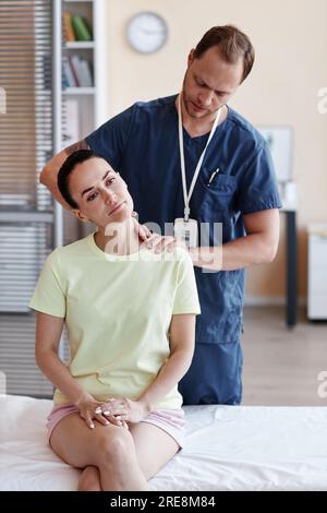Image verticale d'un médecin chez un patient massant uniformément à l'hôpital Banque D'Images