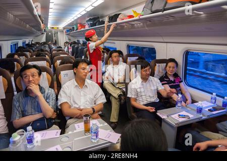 Intérieur de wagon de train à grande vitesse de passagers de chemin de fer chinois avec l'équipage de cabine de chef d'orchestre sur une ligne de train à grande vitesse entre Xi'an et Pékin, en Chine. RPC. (125) Banque D'Images