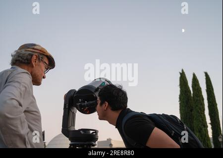 Madrid, Espagne. 25 juillet 2023. Un homme observe la lune à travers un télescope. Le Planétarium de Madrid, en collaboration avec AIRBUS, l’Association astronomique de Madrid (AAM) et l’Agence spatiale européenne (ESA), a organisé une nuit d’observation avec télescopes pour commémorer le 54e anniversaire de l’arrivée des humains sur la Lune. Crédit : Marcos del Mazo/Alamy Live News Banque D'Images