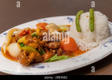Porc aigre-doux avec du riz et des légumes sur l'assiette Banque D'Images