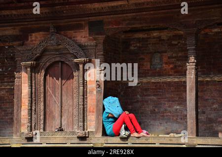 La vie et le mode de vie des femmes népalaises assises se reposer sur le sol de l'ancienne architecture népalaise et ancien bâtiment en ruine à Basantapur Durbar Sq Banque D'Images