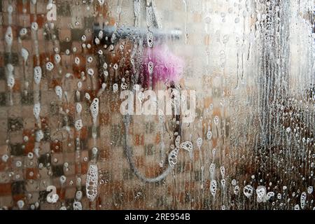 Nettoyage et lavage du calcaire sur la porte vitrée de la salle de bain. Équipement de douche et entretien ménager Banque D'Images