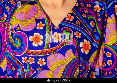 Poitrine de la culture anonyme personne portant chemise colorée vive avec des éléments ornementaux et motif floral Banque D'Images