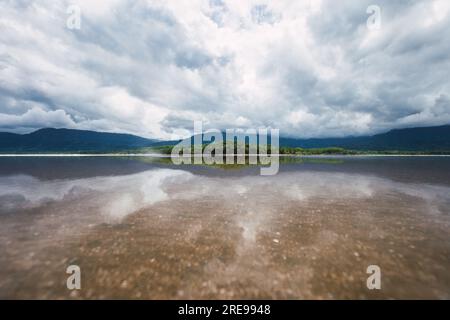 Paysage marin pittoresque de mer transparente calme avec des arbres verts poussant sur l'île contre les montagnes sous le ciel nuageux au Costa Rica Banque D'Images