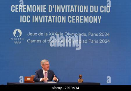 Saint Denis. 26 juillet 2023. Le président du Comité International Olympique (CIO) Thomas Bach signe les invitations lors d’une cérémonie marquant un an avant la cérémonie d’ouverture des Jeux Olympiques de Paris à Saint-Denis, près de Paris, le 26 juillet 2023. Crédit : Gao Jing/Xinhua/Alamy Live News Banque D'Images