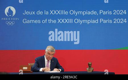 Saint Denis. 26 juillet 2023. Le président du Comité International Olympique (CIO) Thomas Bach signe les invitations lors d’une cérémonie marquant un an avant la cérémonie d’ouverture des Jeux Olympiques de Paris à Saint-Denis, près de Paris, le 26 juillet 2023. Crédit : Gao Jing/Xinhua/Alamy Live News Banque D'Images