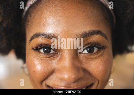 Portrait d'une femme afro-américaine heureuse regardant l'appareil photo et souriant Banque D'Images