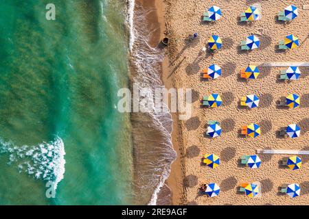 Concept de vacances d'été. Vue d'en haut, vue aérienne magnifique sur une plage incroyable avec parasols de plage et eau turquoise clair. Vue de dessus sur un su Banque D'Images