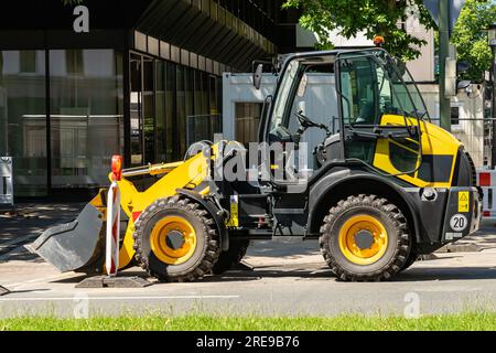 Pelle jaune vif sur un chantier de construction dans la ville. Banque D'Images