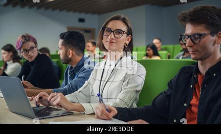 Gros plan Portrait d'un étudiant créatif en lecture. Jeune étudiant à l'université avec divers camarades de classe multiethniques, , participant à la conférence Banque D'Images