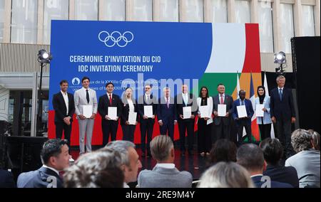 Saint Denis. 26 juillet 2023. Le président du Comité International Olympique (CIO) Thomas Bach (6e L) et le président du comité d’organisation de Paris 2024 Tony Estanguet (1e L) posent avec les délégués lors d’une cérémonie marquant un an avant la cérémonie d’ouverture des Jeux Olympiques de Paris à Saint-Denis, près de Paris, France, le 26 juillet 2023. Crédit : Gao Jing/Xinhua/Alamy Live News Banque D'Images