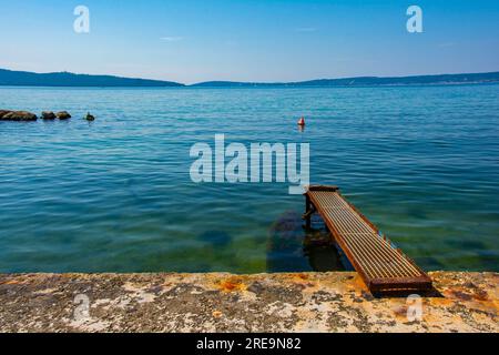 Un ancien débarcadère rouillé sur la côte Adriatique de la Croatie à Kastel Kambelovac à Kastela. Fin du printemps Banque D'Images