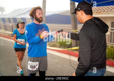 19 juin 2017 : à la fin d'une course à pied à Huntington Beach, CA, un coureur barbu affiche son code barre de classification pour enregistrer son temps de course officiel. Notez le lecteur de codes à barres. (Image de crédit : © Spencer Grant/ZUMA Press Wire) USAGE ÉDITORIAL SEULEMENT! Non destiné à UN USAGE commercial ! Banque D'Images