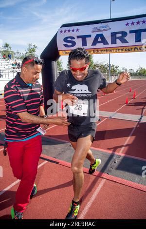 19 juin 2017 : le vainqueur hispanique d'une course à pied franchit la ligne d'arrivée lors d'une compétition sur piste à Costa Mesa, CA, alors que son père atteint offre des félicitations. (Image de crédit : © Spencer Grant/ZUMA Press Wire) USAGE ÉDITORIAL SEULEMENT! Non destiné à UN USAGE commercial ! Banque D'Images