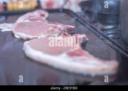 Steak de porc sur un barbecue maison qui est sur le dessus d'un poêle, concept de faire de la nourriture à la maison. Banque D'Images