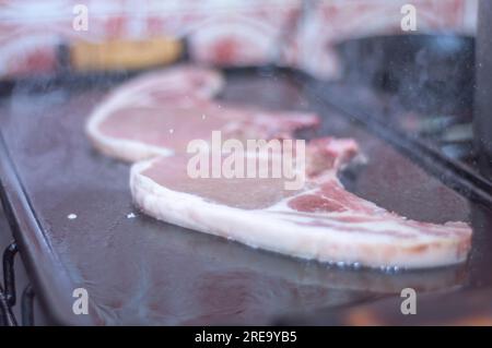 Steak de porc sur un barbecue maison qui est sur le dessus d'un poêle, concept de faire de la nourriture à la maison. Banque D'Images