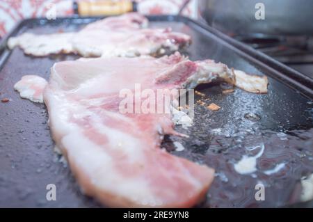 Steak de porc sur un barbecue maison qui est sur le dessus d'un poêle, concept de faire de la nourriture à la maison. Banque D'Images