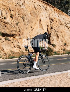 Cycliste faisant du vélo sur une route de montagne Banque D'Images