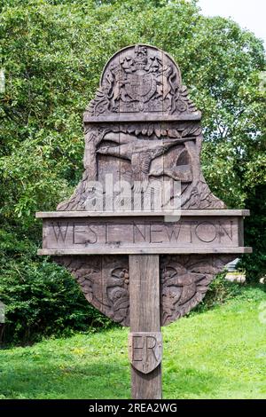 Le panneau de village sculpté en bois pour le village de West Newton sur le domaine de Sandringham dans le Norfolk. Banque D'Images