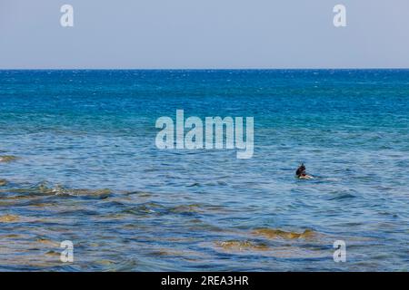 Mer Méditerranée et homme dans le masque de plongée en apnée sur la surface bleue de l'eau de mer. Grèce. Banque D'Images