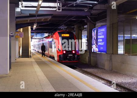 Poznan, Pologne - 19 avril 2023 : gare, le train avant le départ de la plate-forme, l'employé surveille l'embarquement des passagers. Banque D'Images