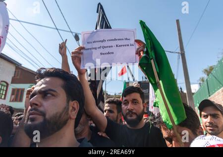 Srinagar, Inde. 26 juillet 2023. Un musulman chiite cachemiri tient une pancarte dénonçant l'incendie du Coran, livre sacré islamique, en Suède, lors d'une procession le 7e jour de Muharram à Srinagar. Muharram est le premier mois du calendrier islamique. C'est l'un des mois les plus sacrés du calendrier islamique. Les musulmans chiites commémorent Muharram comme un mois de deuil en souvenir du martyre du petit-fils du Prophète islamique Muhammad, l'Imam Hussain, qui a été martyrisé à Ashura (10e jour de Muharram) dans la bataille de Karbala en 680 A.D. Crédit : SOPA Images Limited/Alamy Live News Banque D'Images