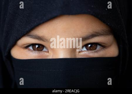 Srinagar, Inde. 25 juillet 2023. Une musulmane cachemirienne regarde vers la procession le 7e jour de Muharram, dans la banlieue de Srinagar. (Photo de Faisal Bashir/SOPA Images/Sipa USA) crédit : SIPA USA/Alamy Live News Banque D'Images