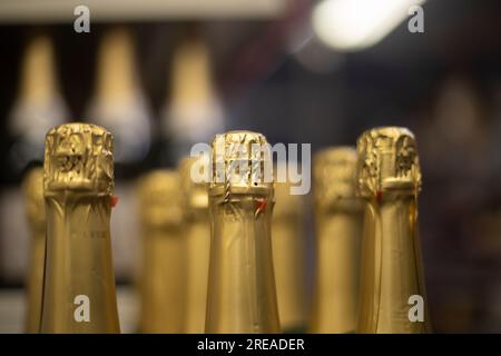 Champagne avec feuille d'or. Bouteilles de vin en magasin. Les boissons alcoolisées sont rangées. Détails de vente des bouteilles. Banque D'Images