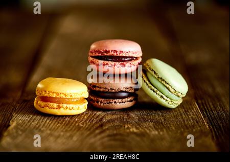 Macarons de différentes saveurs sur surface en bois rugueux Banque D'Images