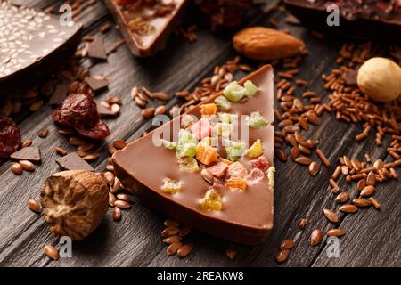 Composition créative chocolat sous forme de pizza aux fruits confits, noix, baies sèches, pizza au chocolat et ingrédients sur un bois sombre Banque D'Images