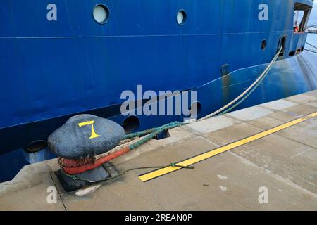 Une grosse borne portuaire et une ligne d'amarrage de navire sur un quai. Banque D'Images