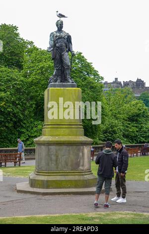 Deux hommes regardant la carte, devant la statue de David Livingstone, sculptée par Amelia Robertson Hill, East Princes Street Gardens, Édimbourg, Royaume-Uni. Banque D'Images