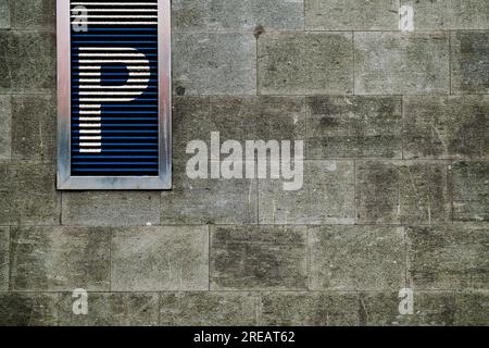 Parking de la ville marqué avec la grande lettre P sur un mur de pierre. Banque D'Images