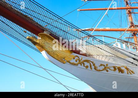 Détail d'un voilier classique, figure de proue dorée et badge. Banque D'Images