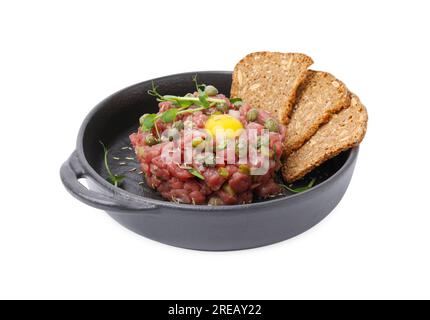 Savoureux steak tartare de bœuf servi avec jaune, câpres et pain tranché isolé sur blanc Banque D'Images