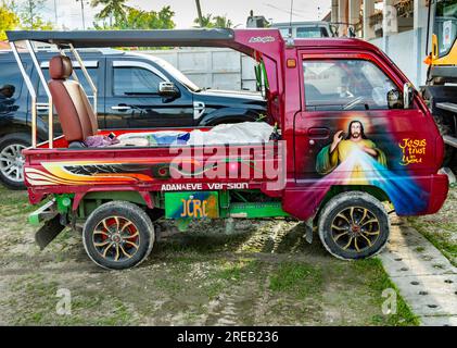 Oslob, Cebu, Philippines-janvier 27 2023 : garé à côté de l'église Oslob, un petit camion-camionnette improvisé, est décoré avec flamboyant et un peu humo Banque D'Images