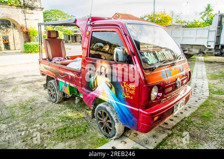 Oslob, Cebu, Philippines-janvier 27 2023 : garé à côté de l'église Oslob, un petit camion-camionnette improvisé, est décoré avec flamboyant et un peu humo Banque D'Images