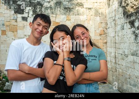 Oslob, Cebu, Philippines-janvier 27 2023 : prendre une pause dans une routine de danse, utiliser les ruines comme emplacement, trois amis, des adolescents locaux demandent à Banque D'Images