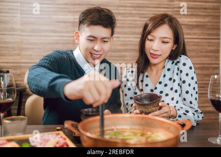 Heureux couple dînant dans le restaurant Hotpots Banque D'Images