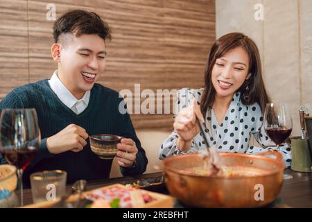 Heureux couple dînant dans le restaurant Hotpots Banque D'Images