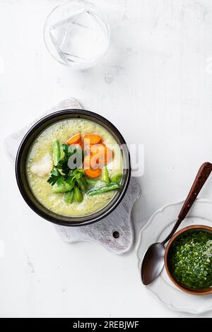 Soupe minestrone avec sauce pesto au persil, soupe à la crème de légumes, repas végétalien sain, vue à grand angle Banque D'Images