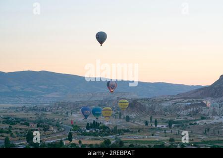 Goreme, Turquie, le 18 juillet 2023 : un ballon survole la Cappadoce, tirant depuis la colline. Banque D'Images